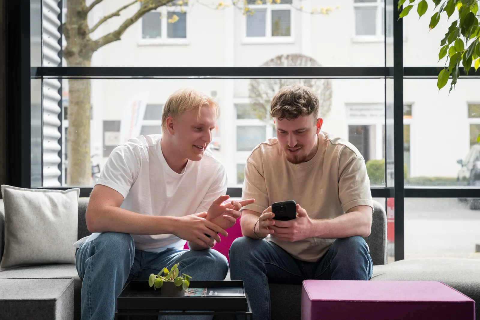 Alex Kohl und Andi Ashani prüfen eine Landingpage auf dem Handy